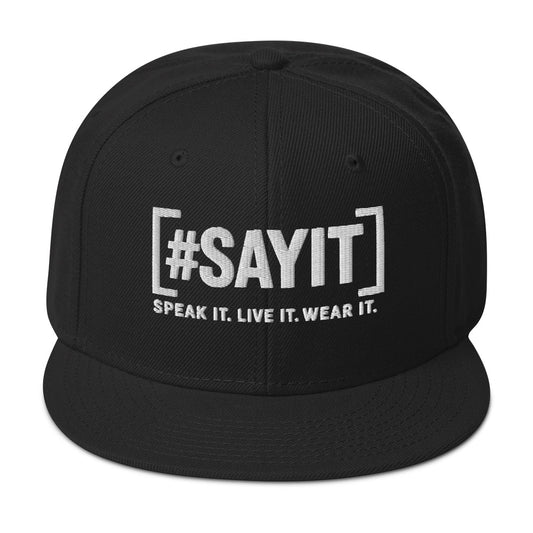 Casquette snapback structurée avec visière plate, marquée du slogan #SAYIT sur le devant. Style urbain affirmé pour une expression directe et engagée.